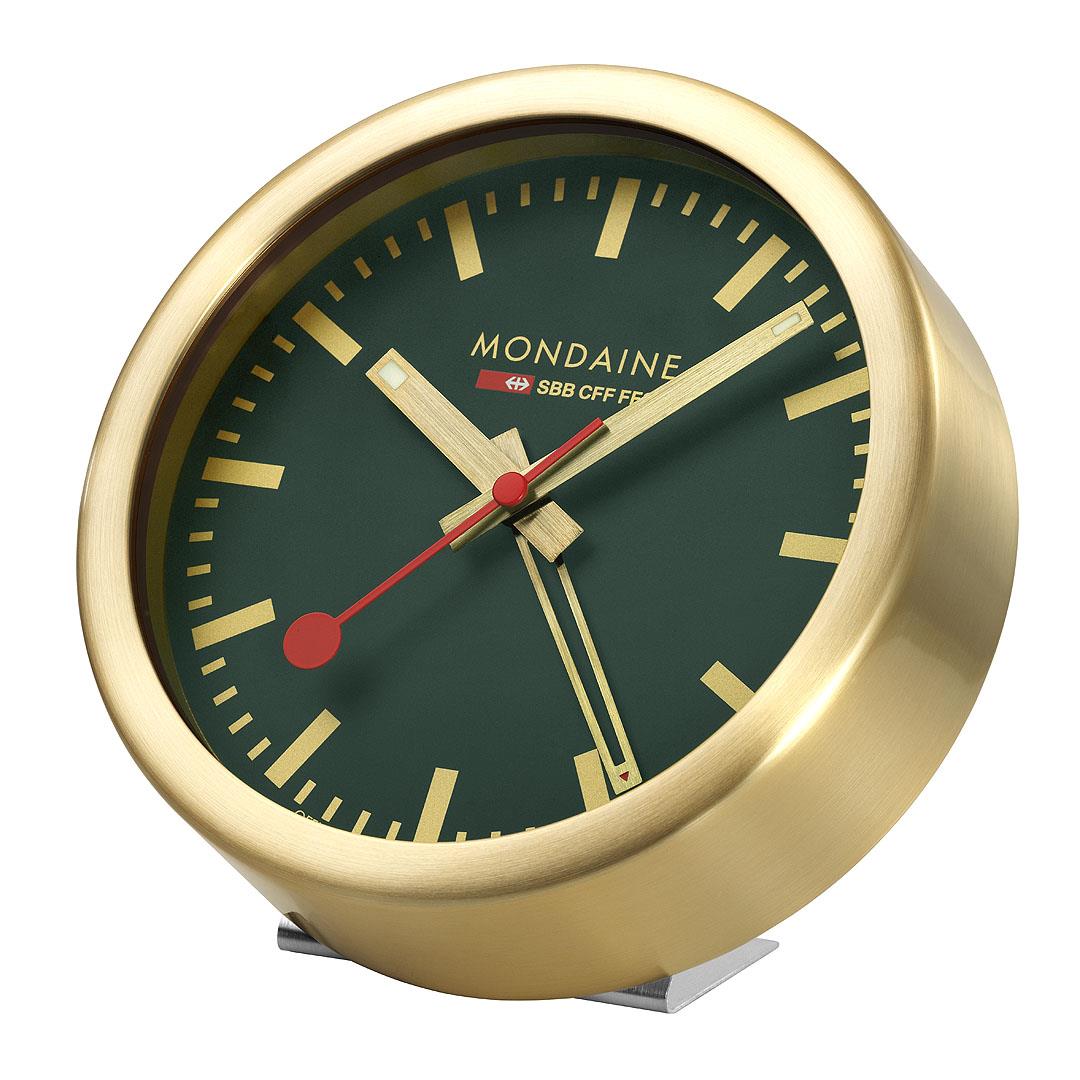 Gold-tone table clock with forest green dial, red hands, and raised base stand.