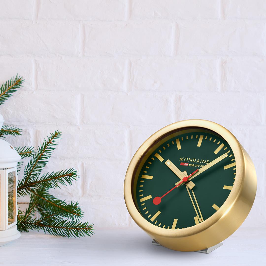 Gold-tone table alarm clock with forest green dial, red hands and twin bell-style feet
