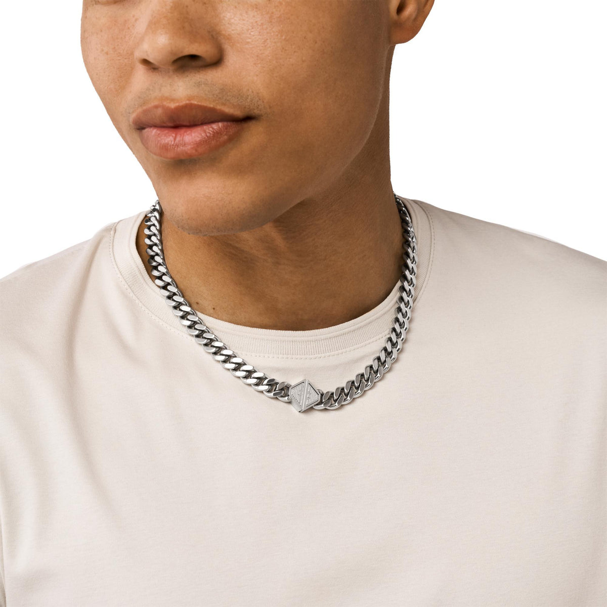Stainless steel chain necklace with triangular logo pendant on model, silver-tone