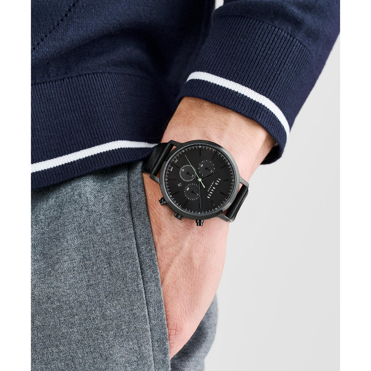 Men's black dial leather watch on wrist, black strap and chrono-style subdials