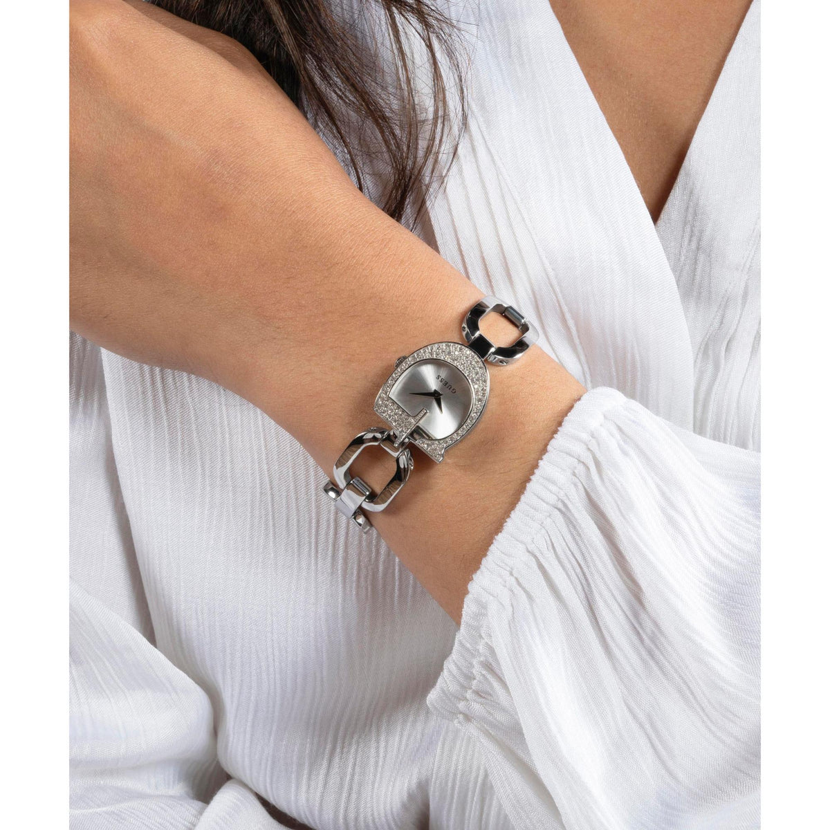 GUESS silver-tone watch with crystal dial bezel and chunky link bracelet on wrist
