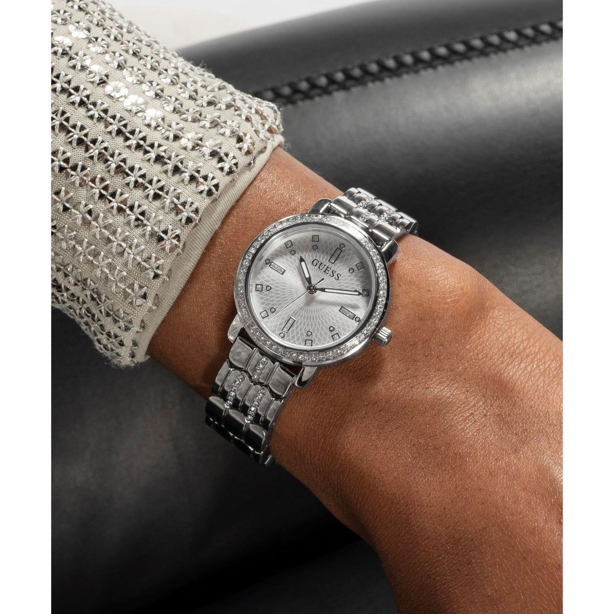 Silver-tone ladies wrist watch close-up with crystal bezel and metal link strap.
