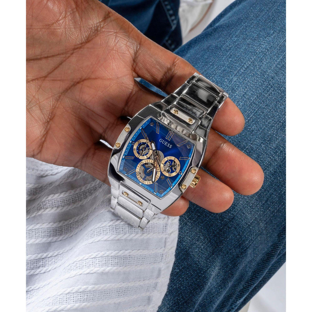 GUESS men's wristwatch close-up: blue dial with subdials, silver-tone link strap