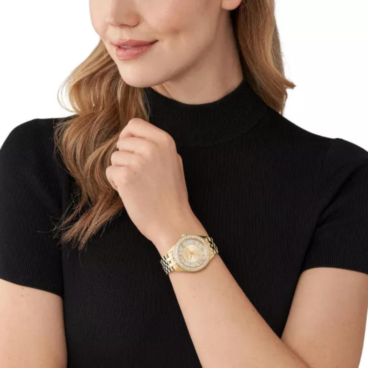 Gold-tone Michael Kors watch on wrist with oval crystal bezel and gold dial
