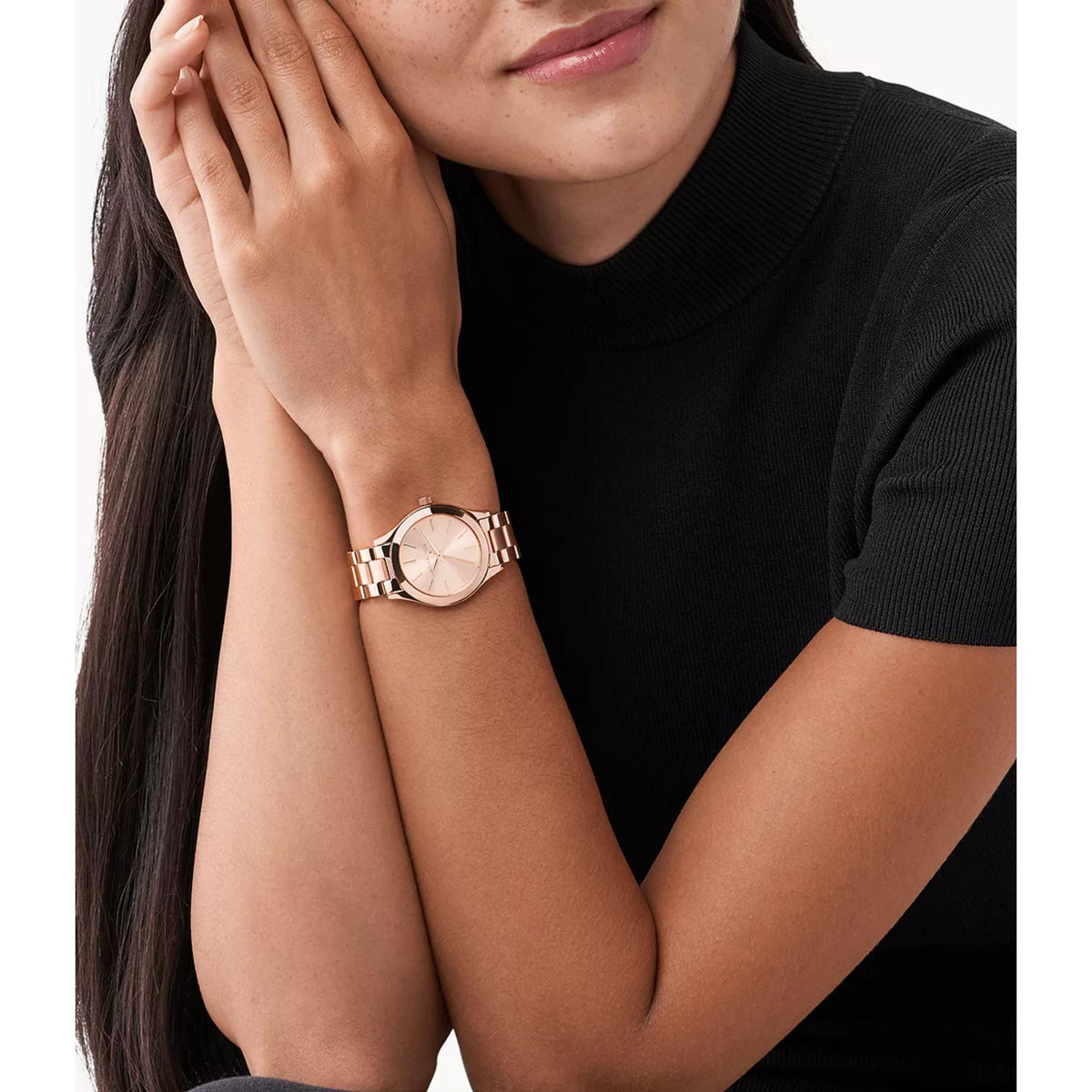 Women’s rose gold-tone watch worn on wrist with link bracelet and rose dial