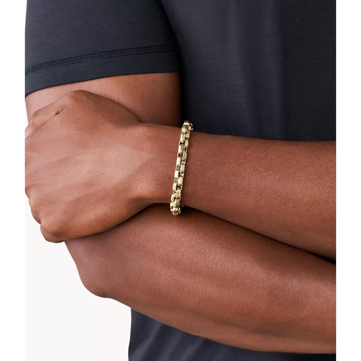Gold-tone chain bracelet on wrist, highlighting the interlocking link design