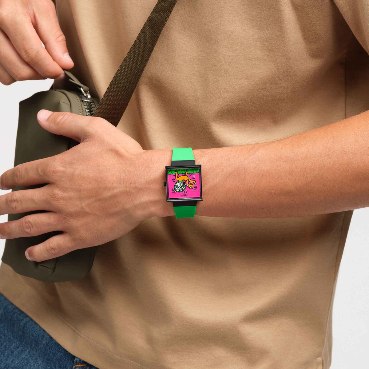Swatch women's wristwatch with pink square dial, black case, and green silicone band
