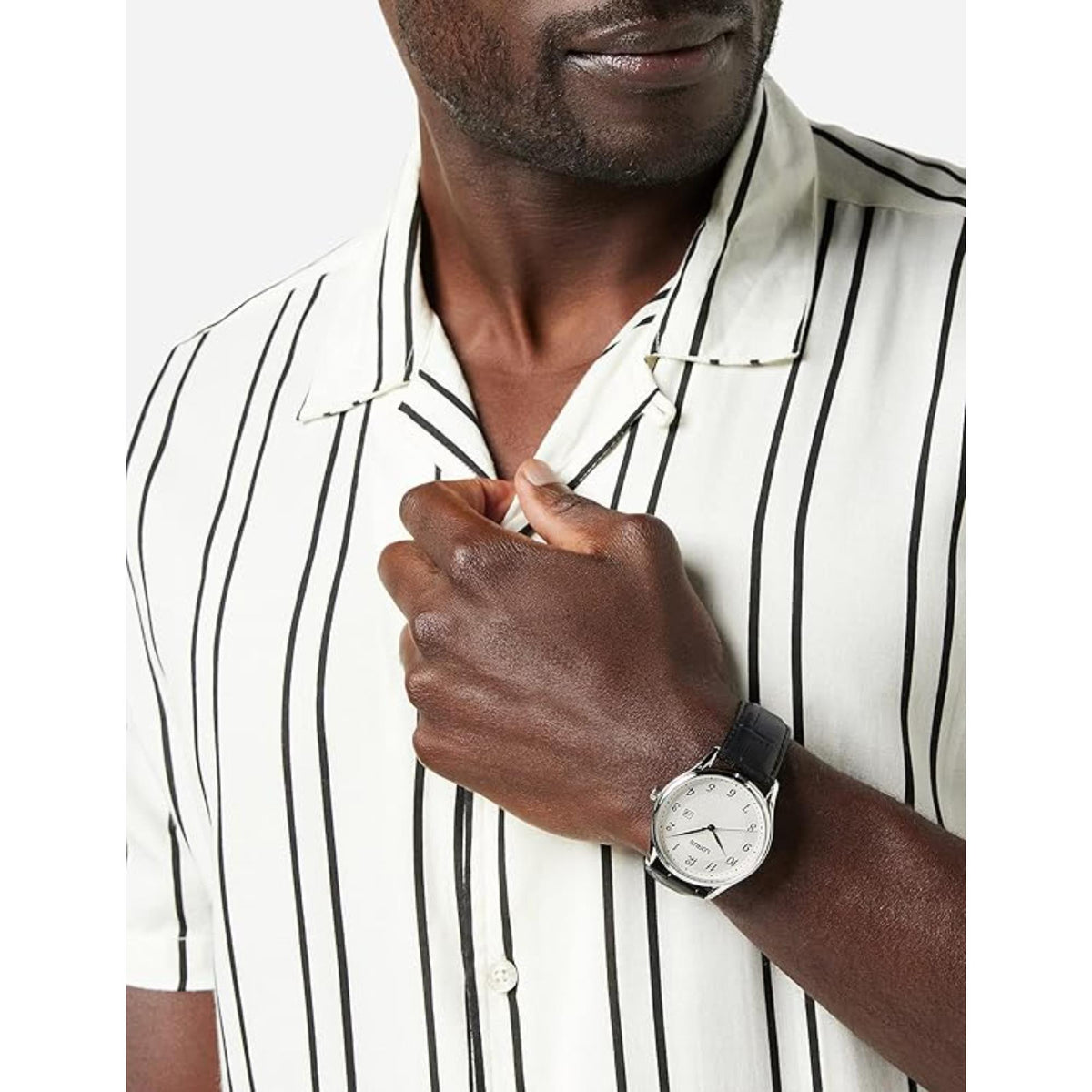 Men's wristwatch worn on wrist with white dial and black leather strap