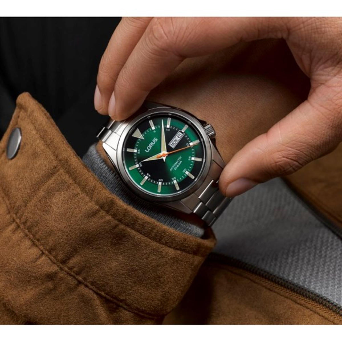 Men’s automatic watch with green dial, silver metal bracelet, worn on wrist
