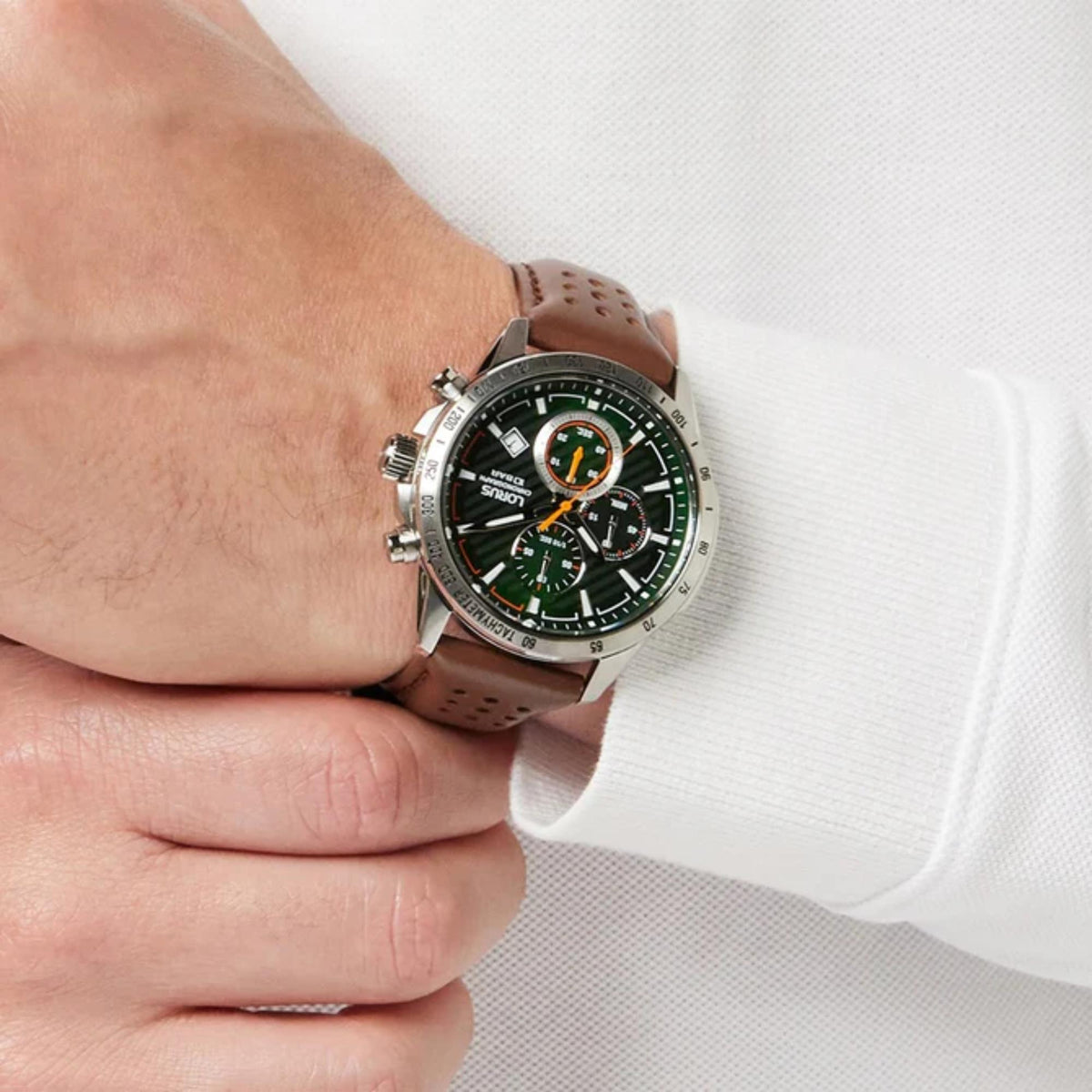 Men's green dial chronograph watch on wrist, brown leather strap and silver case