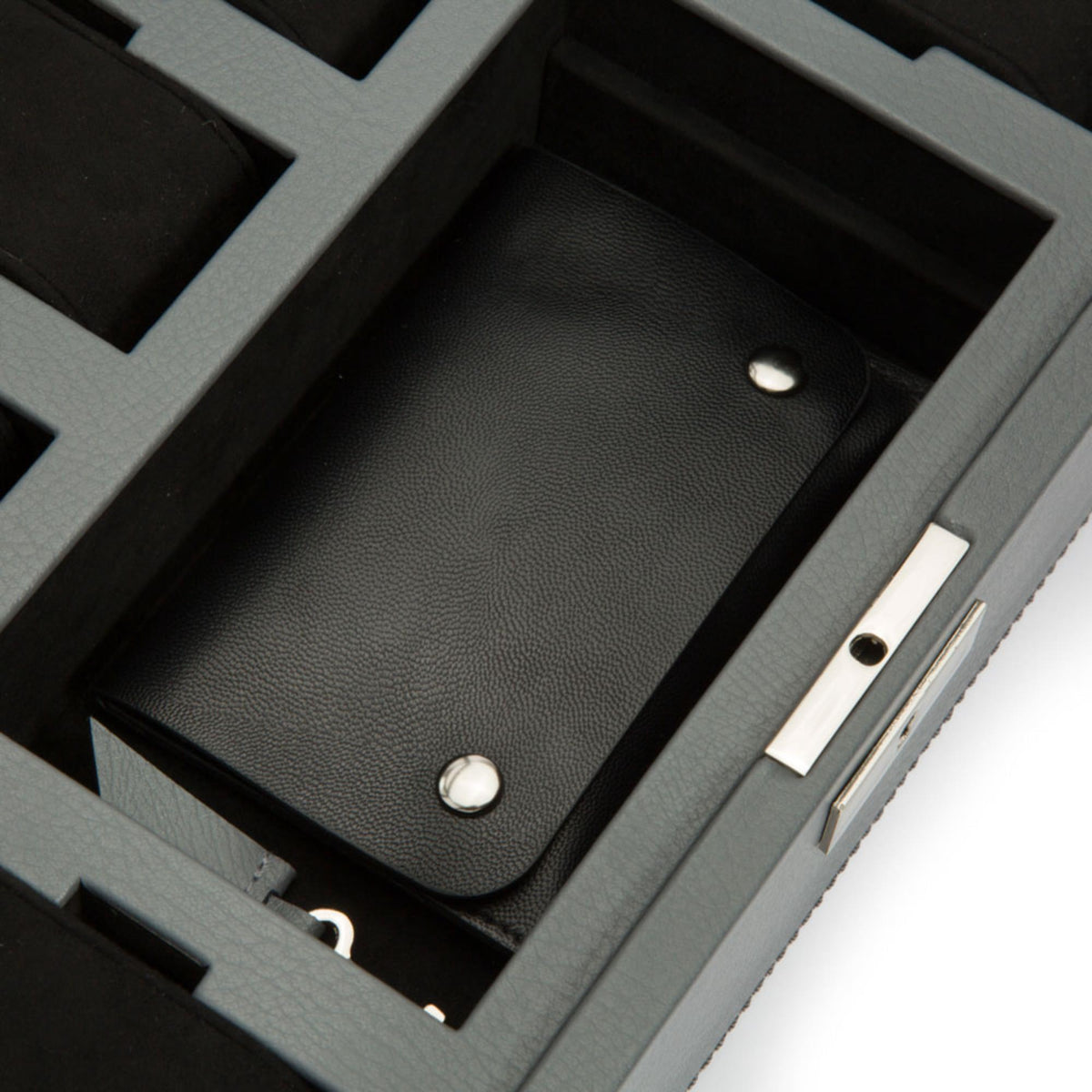 Close-up of black leather watch strap pad inside gray watch box compartment