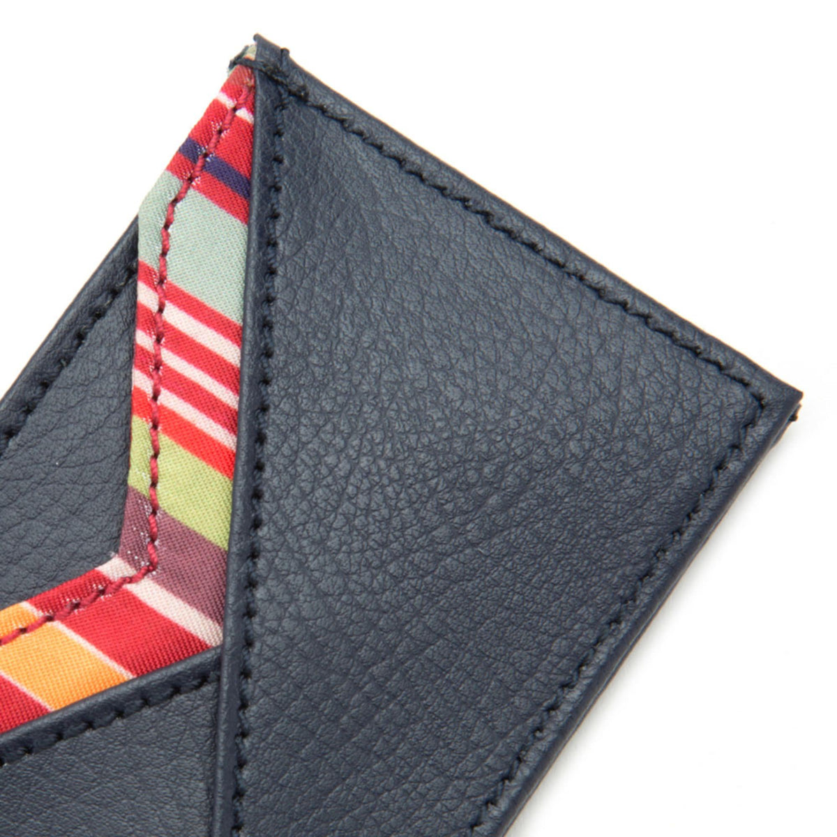 Dark navy card wallet edge close-up with contrast stitching and striped lining.