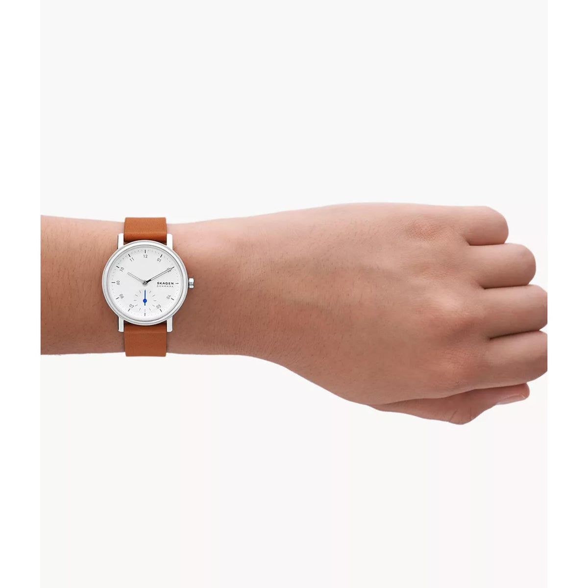 Skagen women's watch worn on wrist with brown leather band and white dial