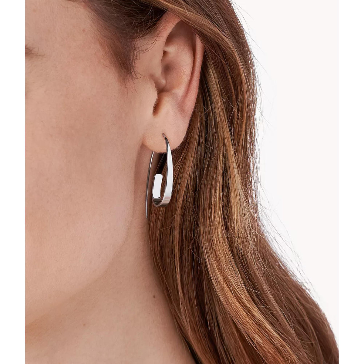 Silver-tone teardrop hoop earrings on ear, angled open loop with clasp