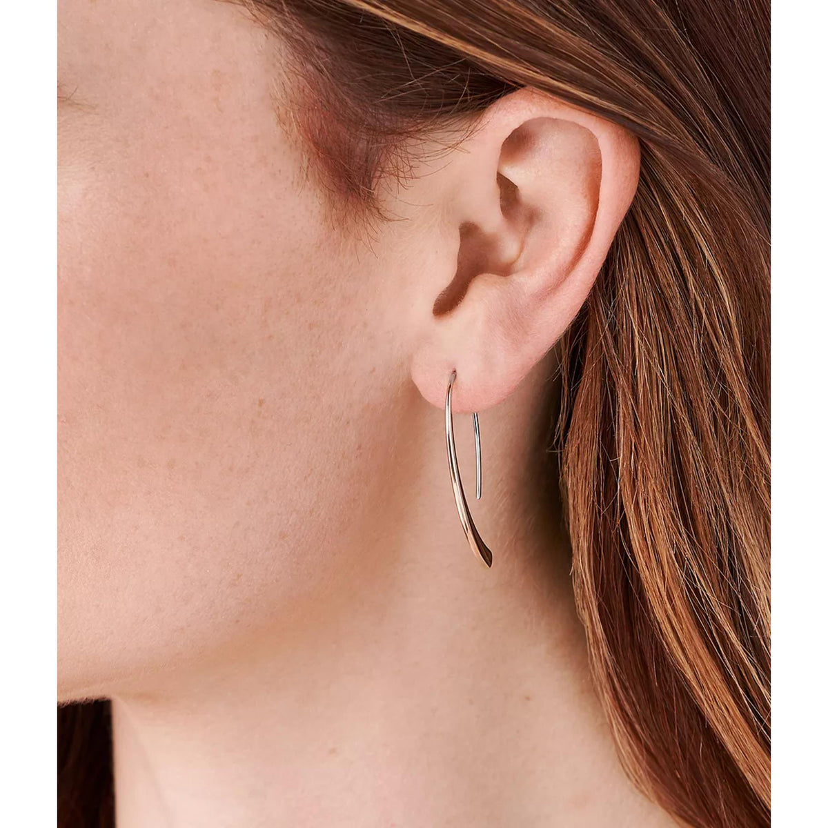 Rose gold-tone threader hoop earrings close-up on ear, slim two-tone curved hoops