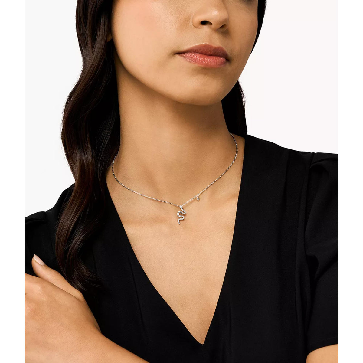 Sterling silver pendant necklace on model’s neckline with letter charm pendant