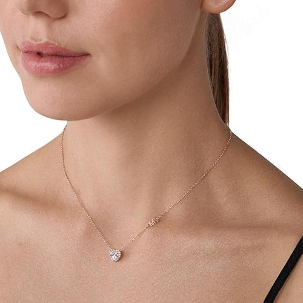 Rose gold heart pendant necklace on model, showing center stone and chain links