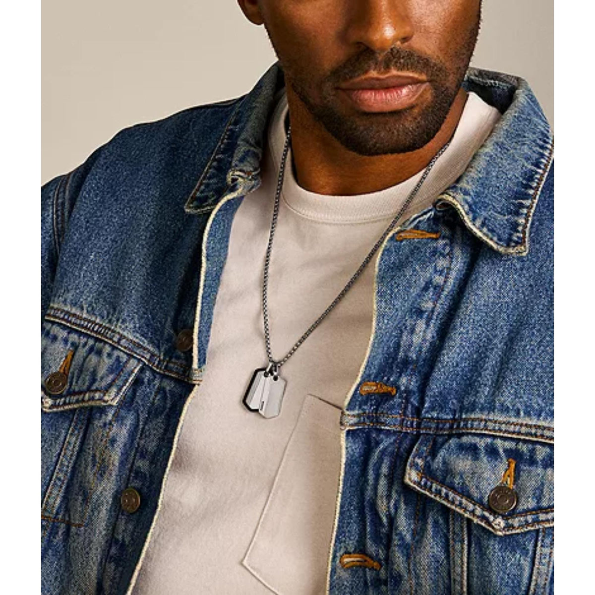 Stainless steel dog tag necklace with two hexagonal pendants worn on a man’s neck