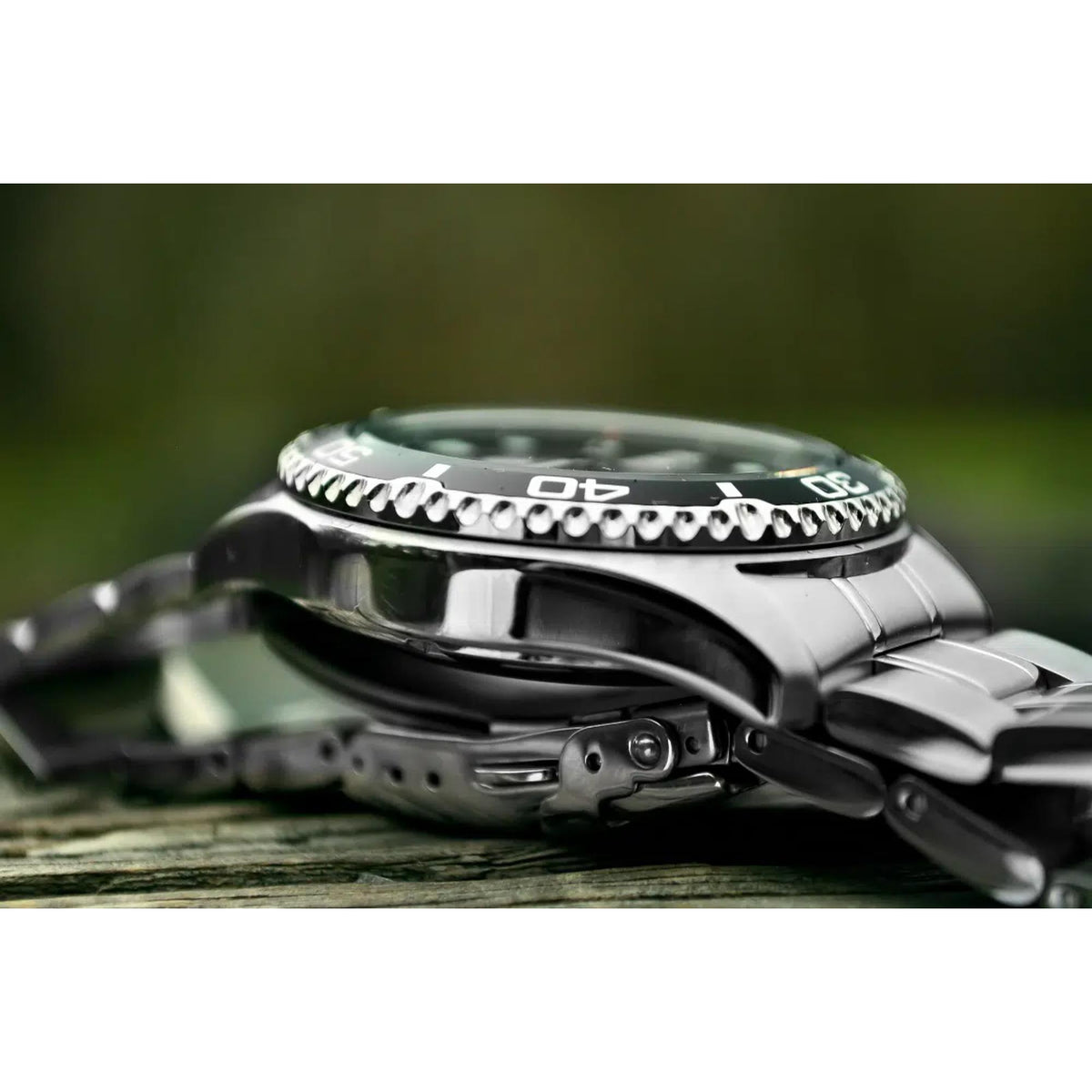 Stainless steel diver watch with ridged bezel and black strap