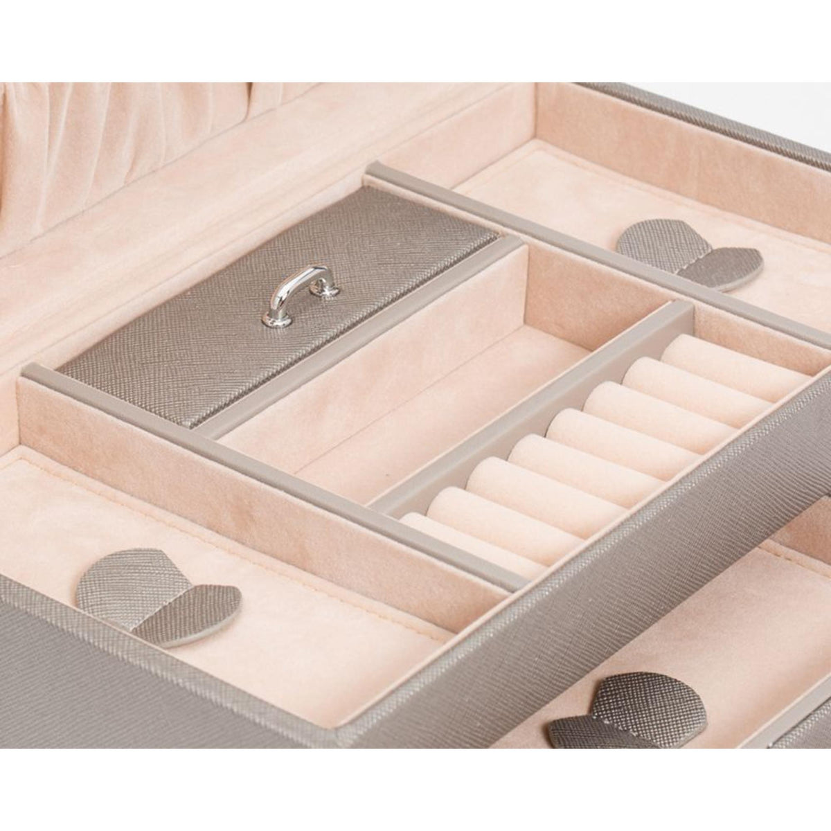 Small jewelry box with open lid showing ring slots and padded compartments in tan tones