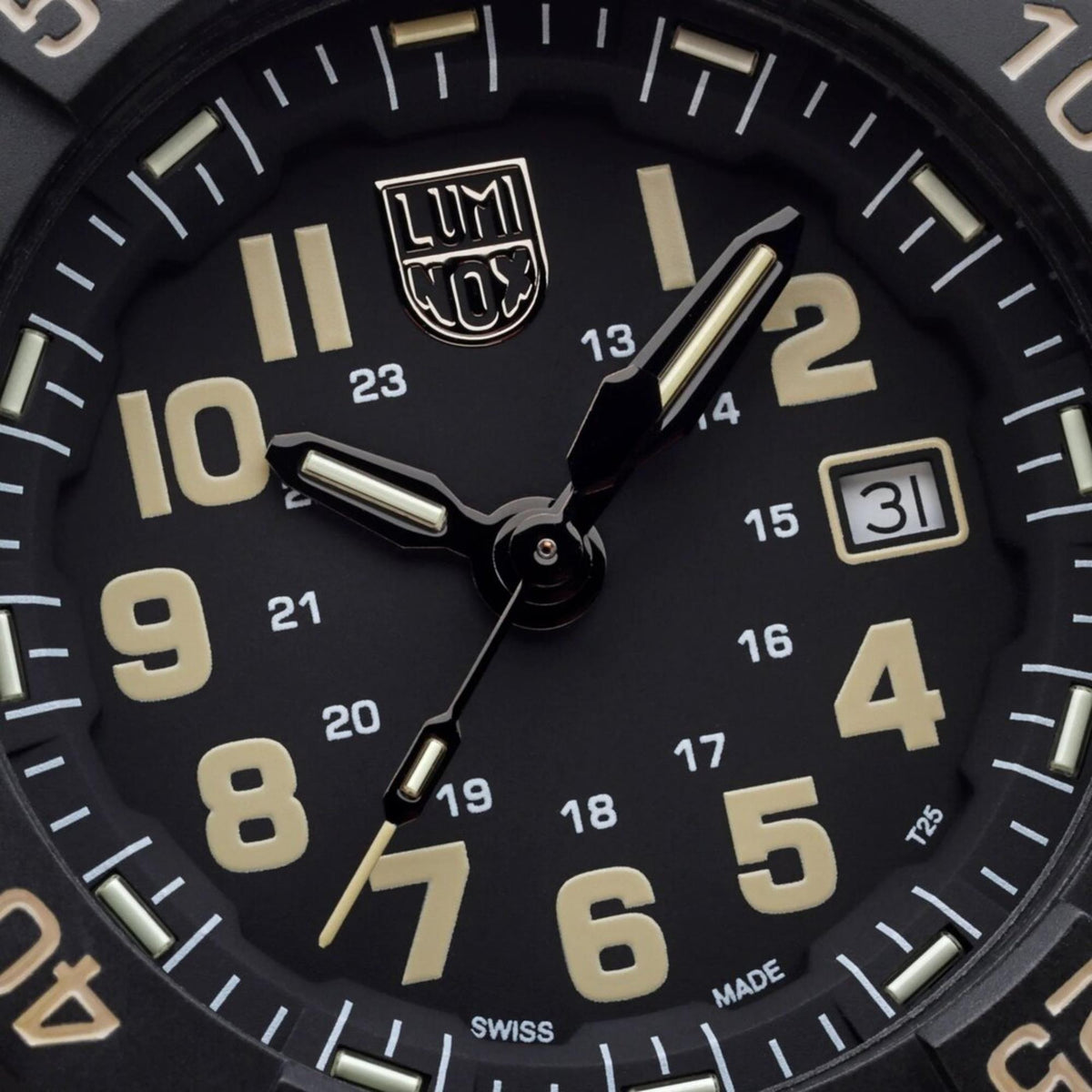 Black watch dial close-up with gold hour markers and date window at 3 o'clock.