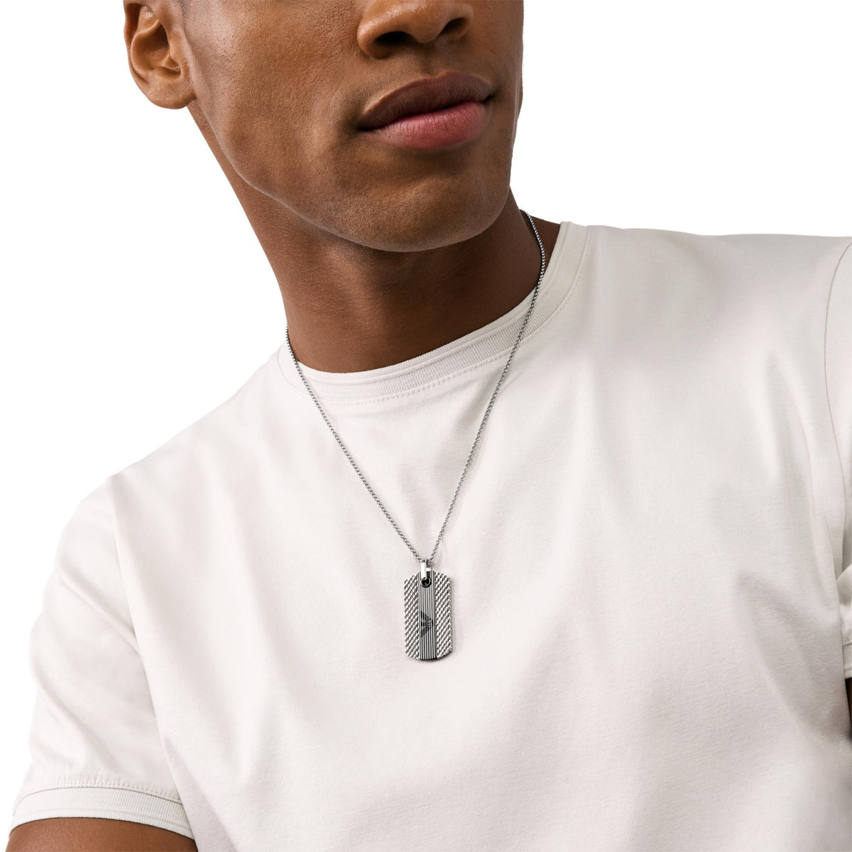 Stainless steel dog tag pendant necklace close-up on white T-shirt