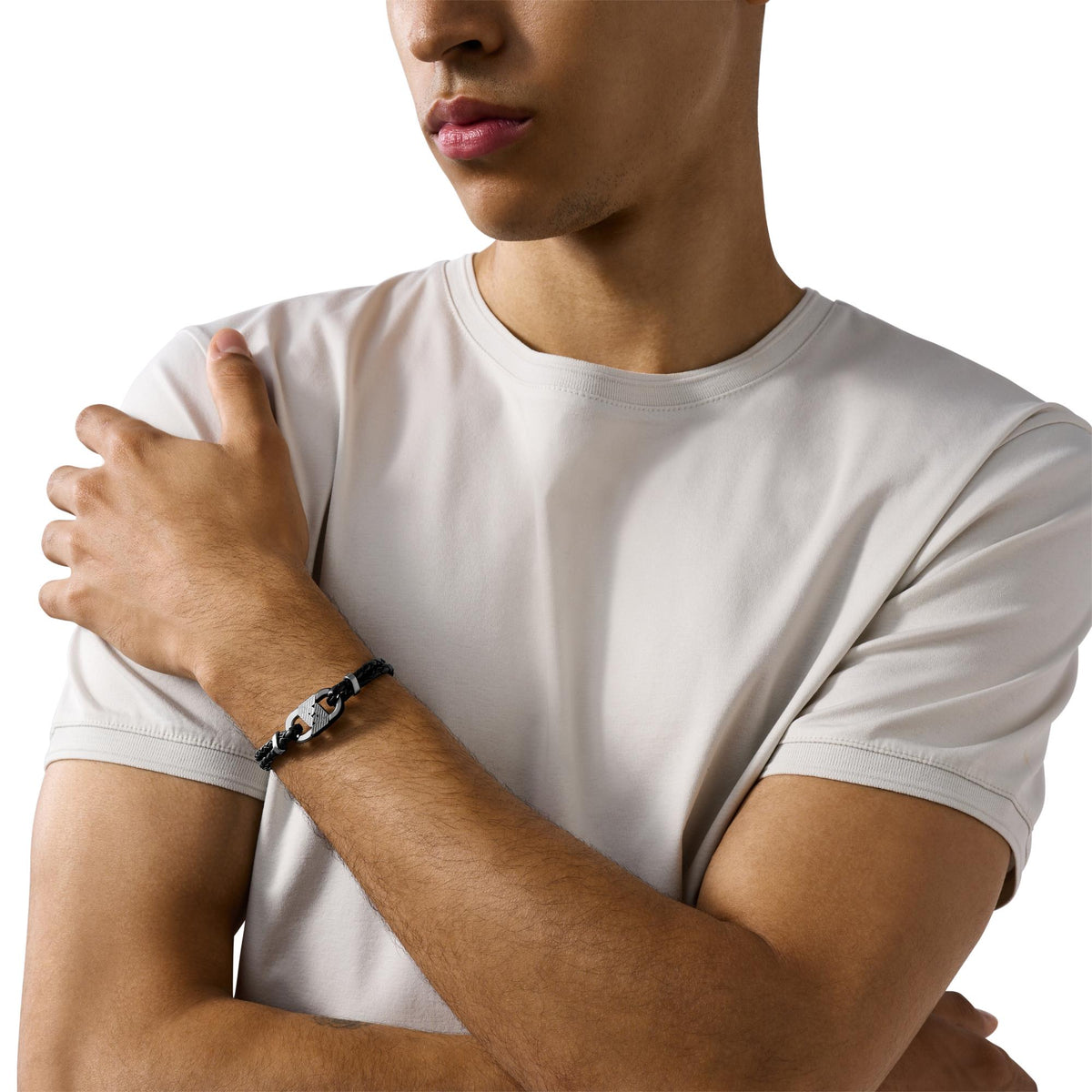 Men's Emporio Armani ID bracelet on wrist with black braided strap and two-tone stainless steel links