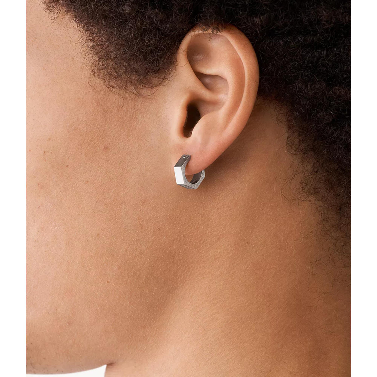 Stainless steel hoop earring on ear, close-up side view