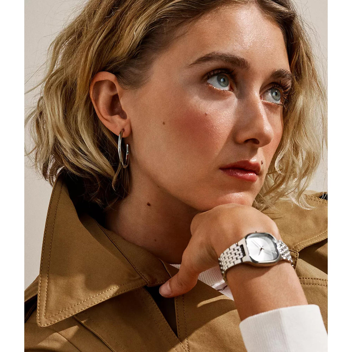 Silver-tone hoop earrings on model, polished open oval hoops with visible clasp