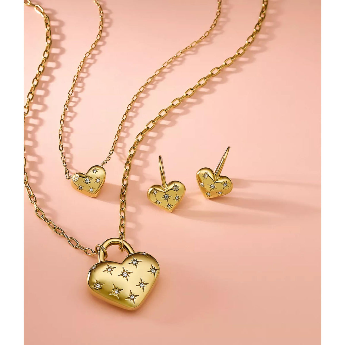 Gold-tone heart drop earrings with star pattern, small heart dangles