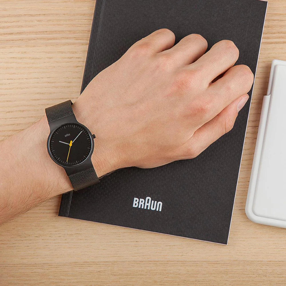 Braun men's watch worn on wrist with black dial and black steel mesh strap