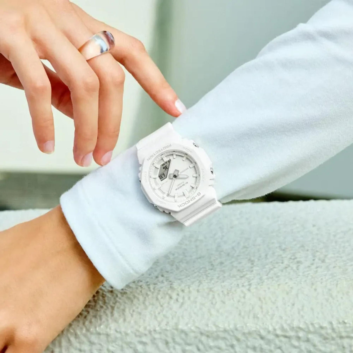 On-wrist close-up of white G-Shock watch with resin strap and analog-digital dial