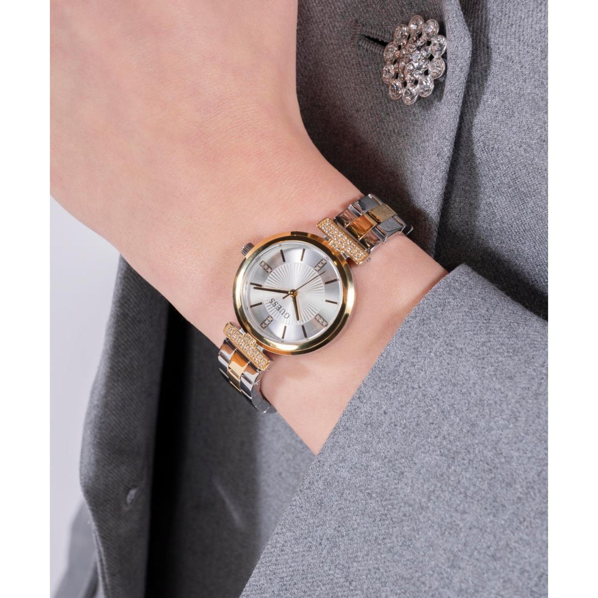 Two-tone stainless steel women's watch with silver dial and jeweled bezel on wrist