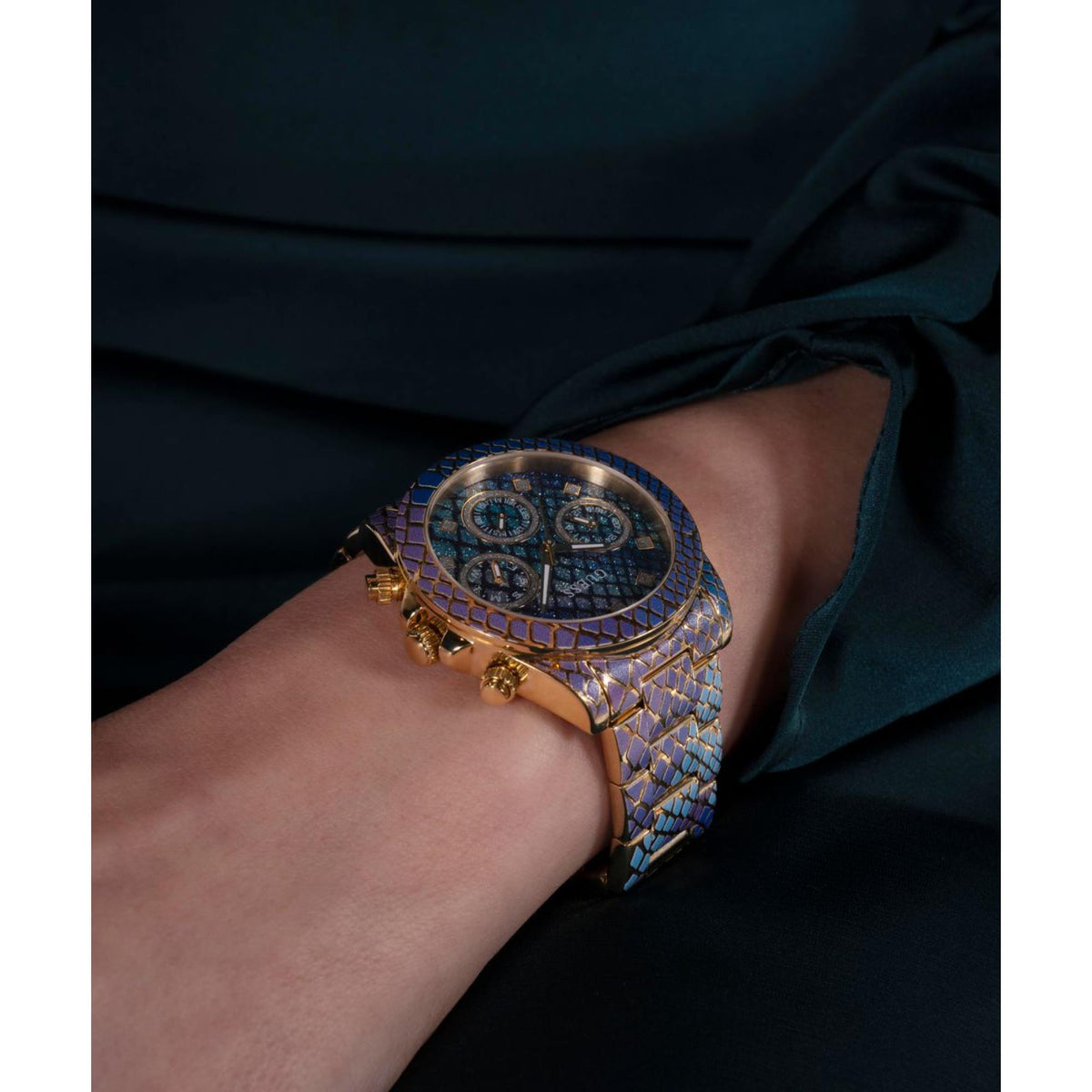 Women's Guess wrist watch with blue patterned strap and gold-toned case, blue dial visible.