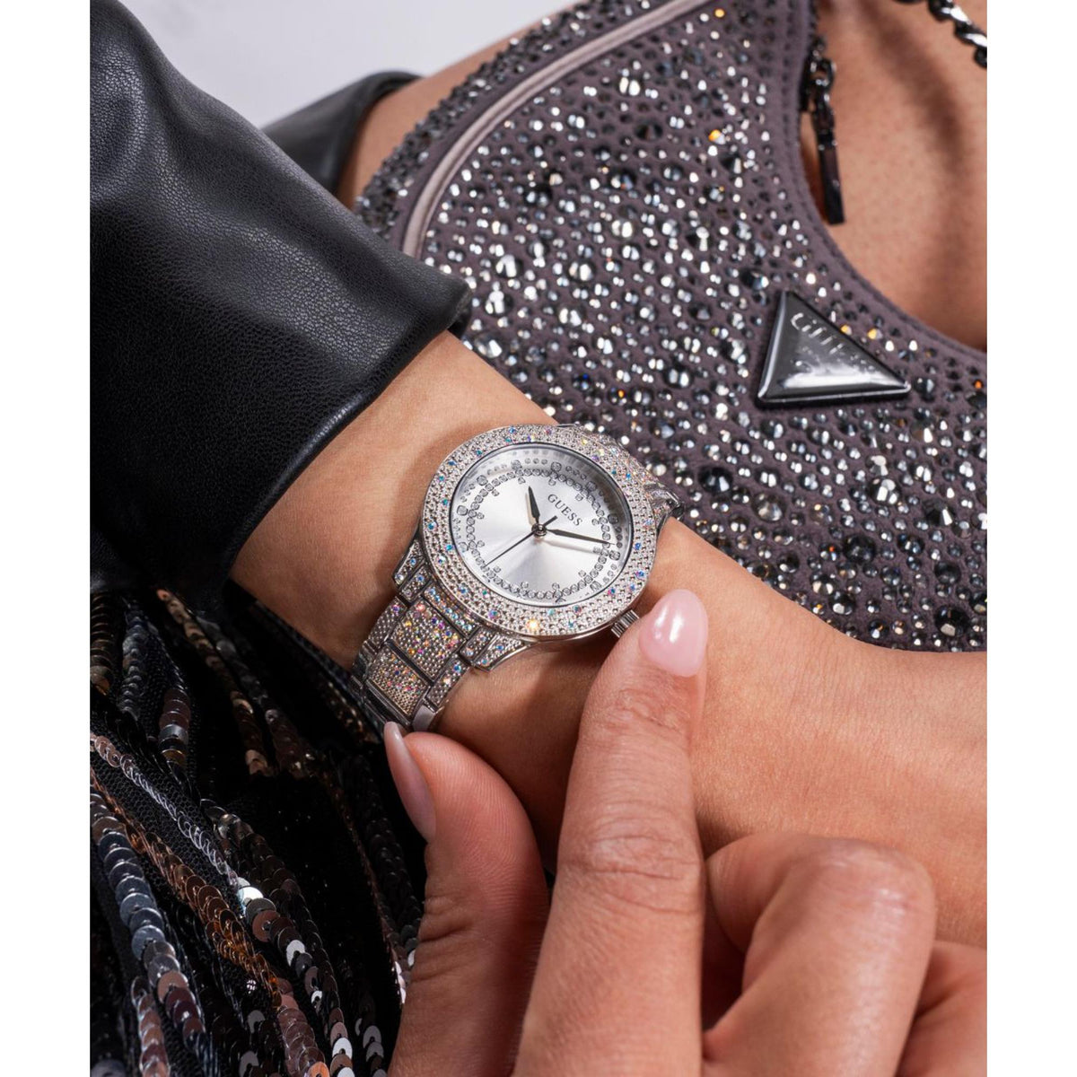 Women’s crystal bezel watch on wrist with silver dial and crown detail