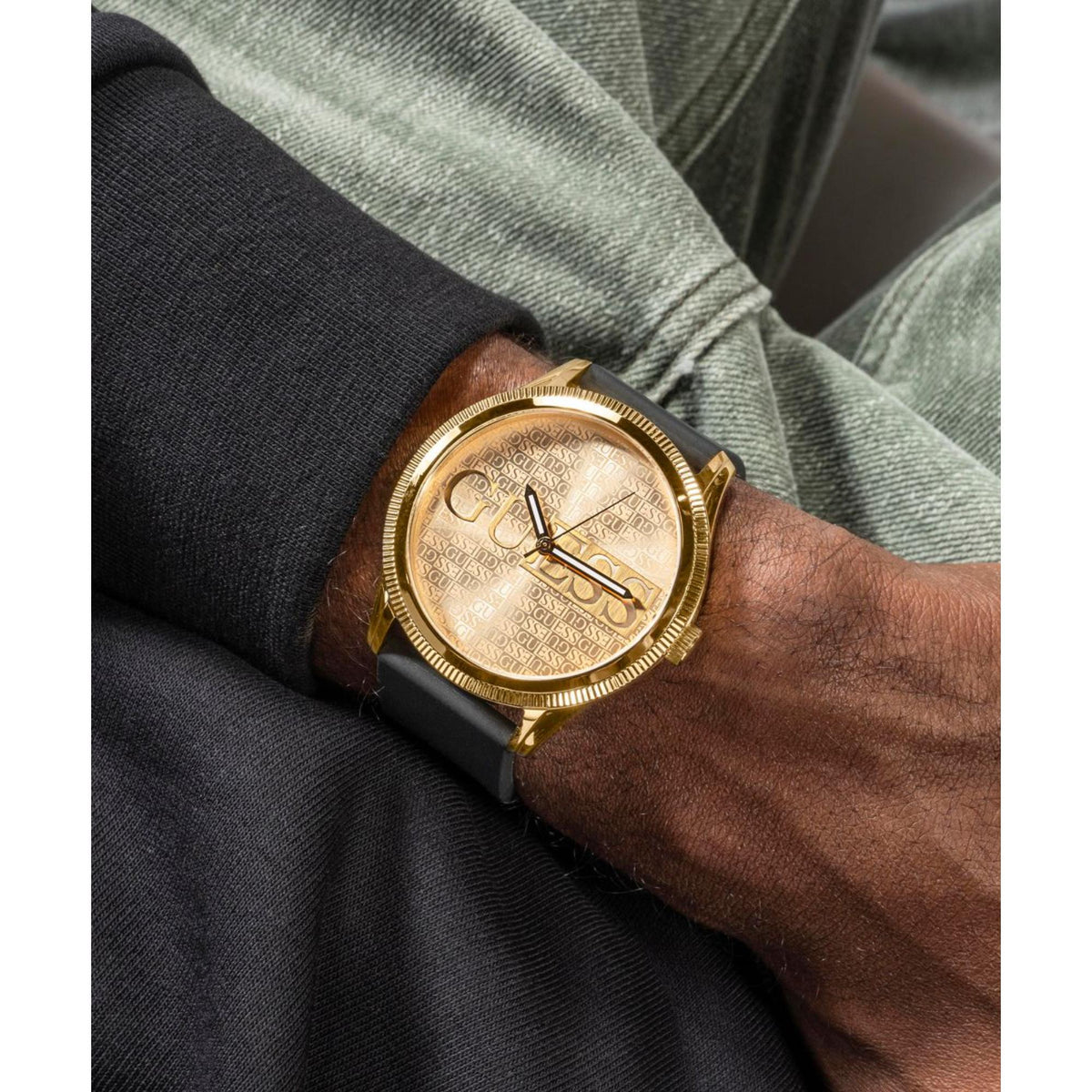 Men's watch worn on wrist with champagne dial, gold case, and black silicone strap