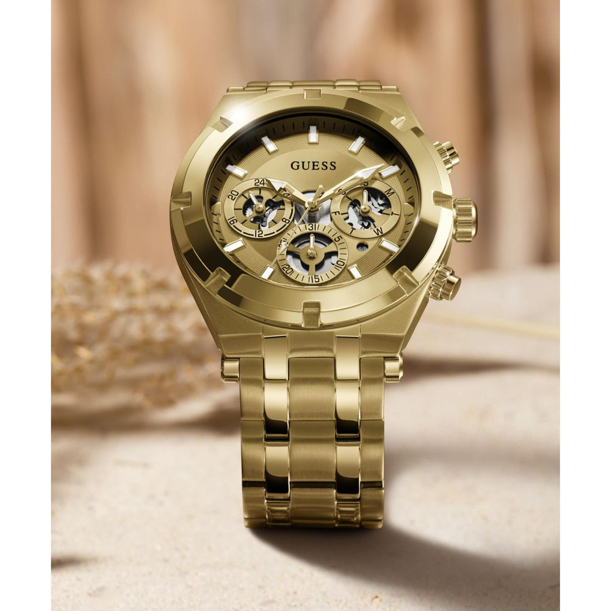 Gold-tone stainless steel men’s skeleton watch on wrist, round dial with subdials.
