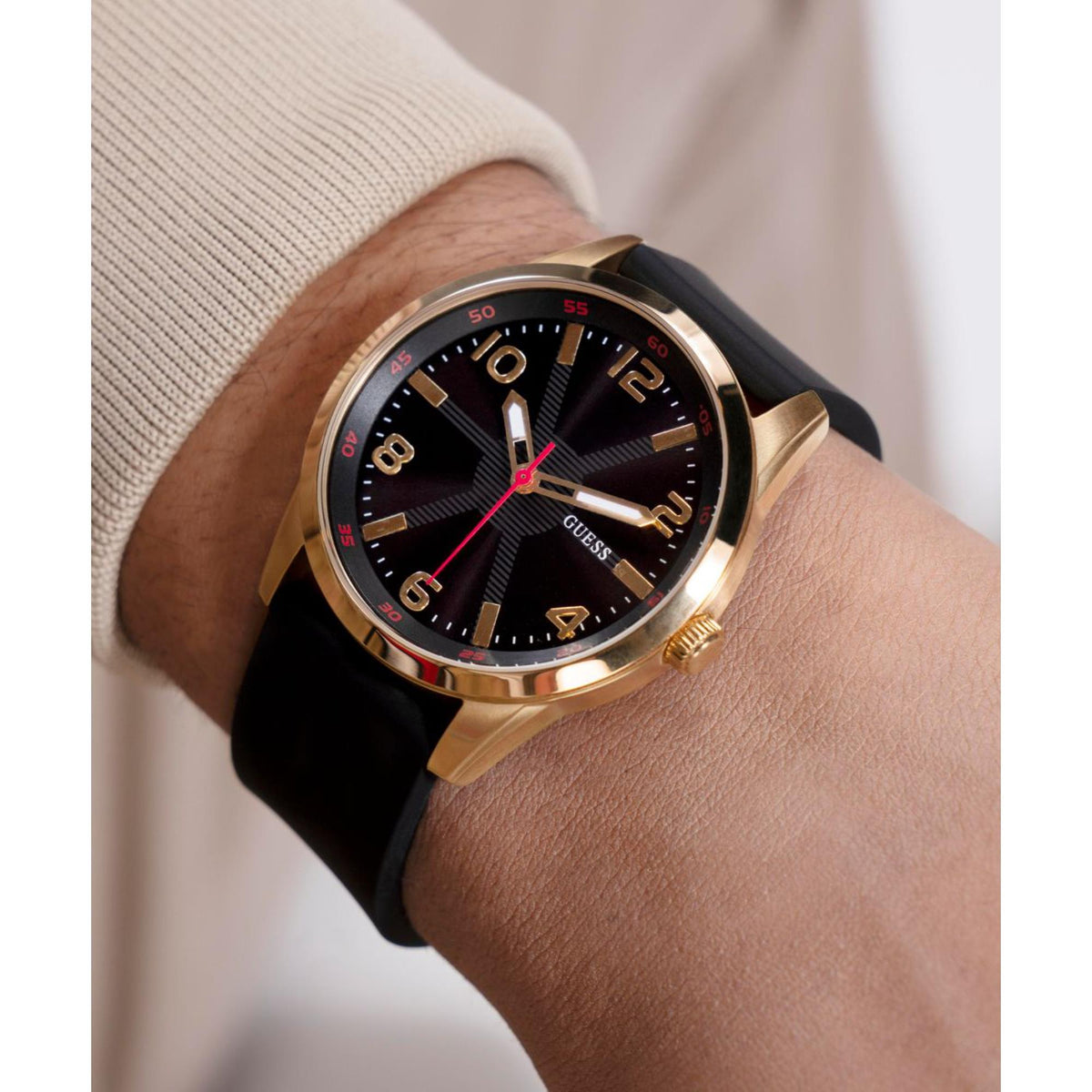 Men’s wristwatch with black dial and gold-tone bezel, red hands, black silicone strap.
