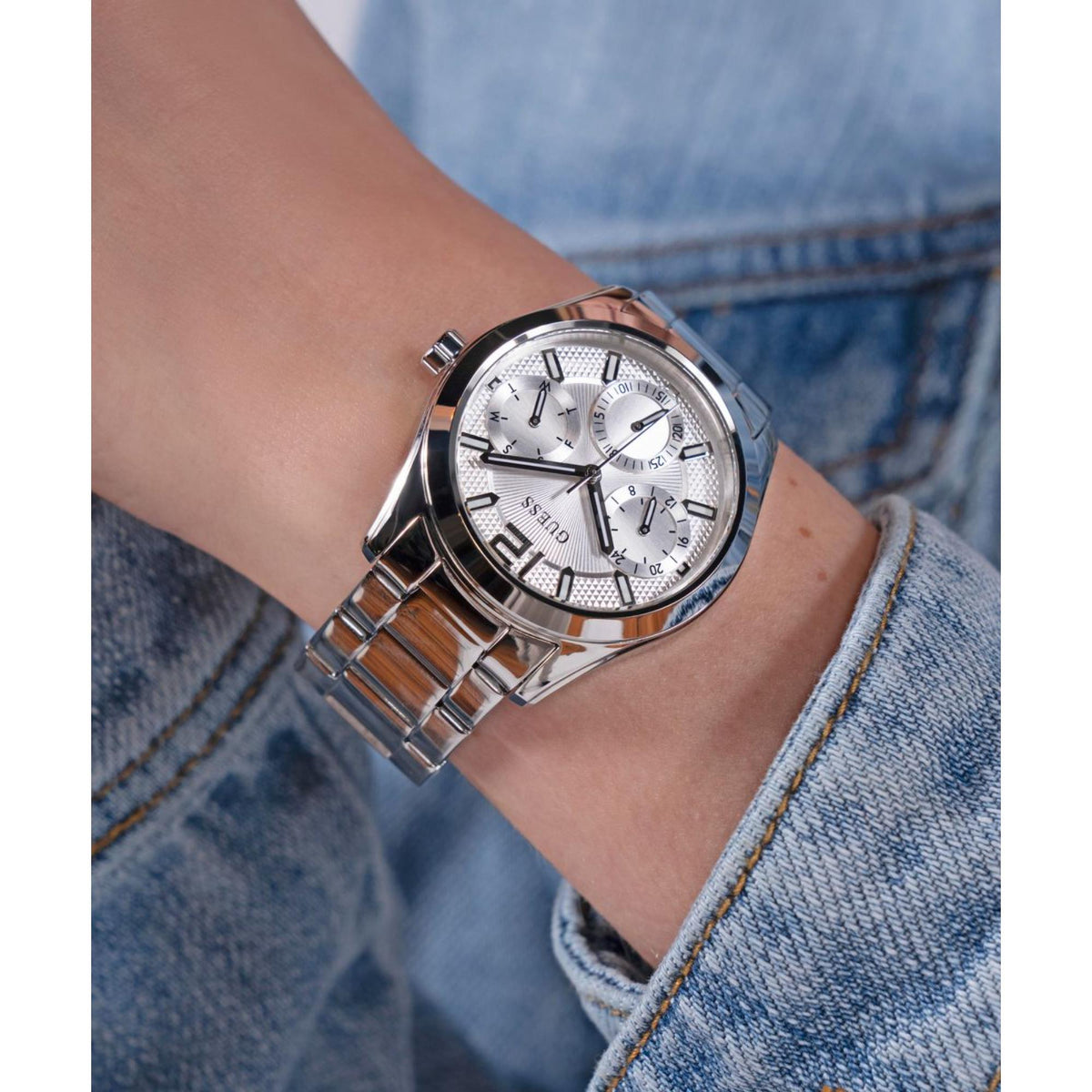 Women's silver dial stainless steel watch with three subdials on denim wrist