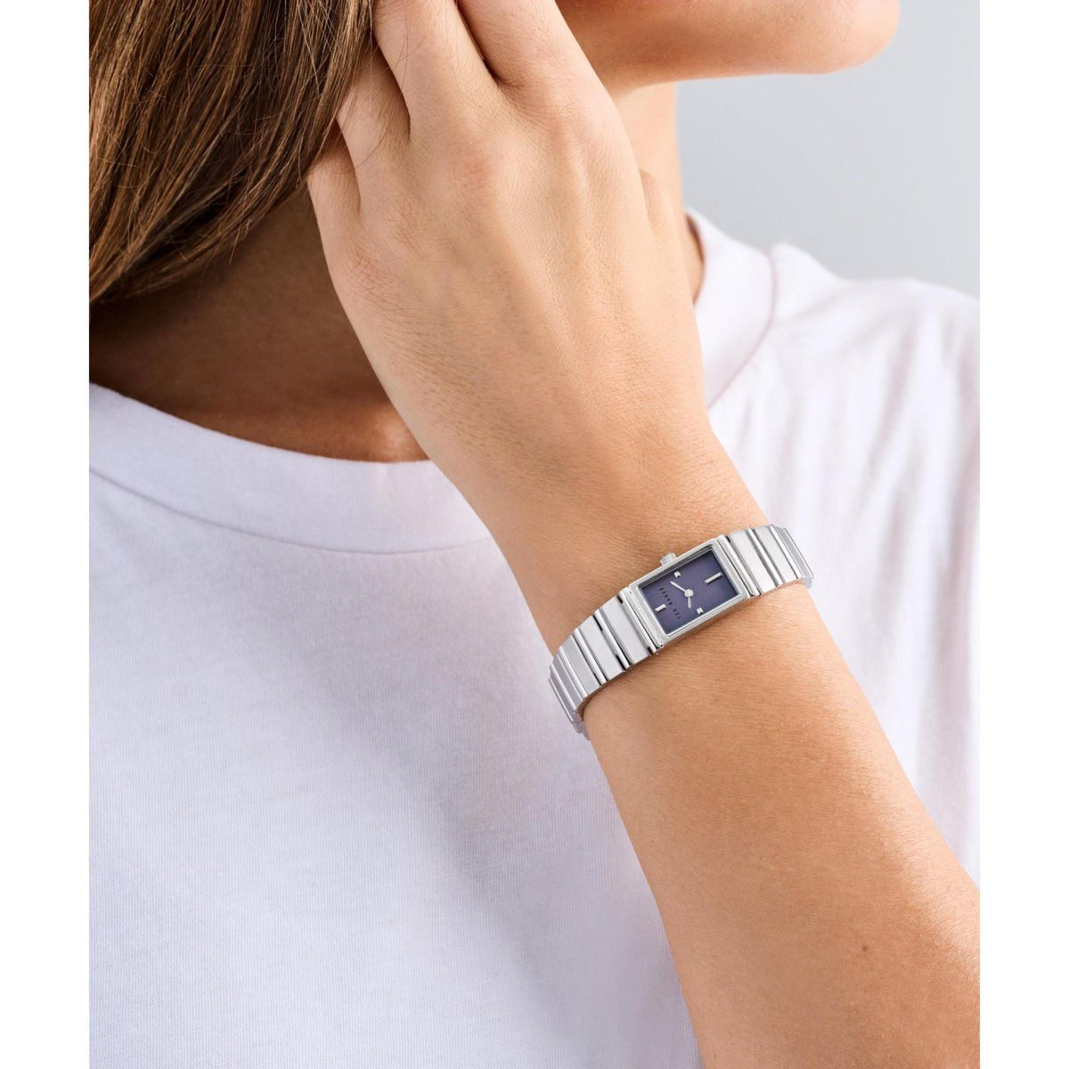 Person wearing ladies stainless steel watch with blue dial and metal link bracelet