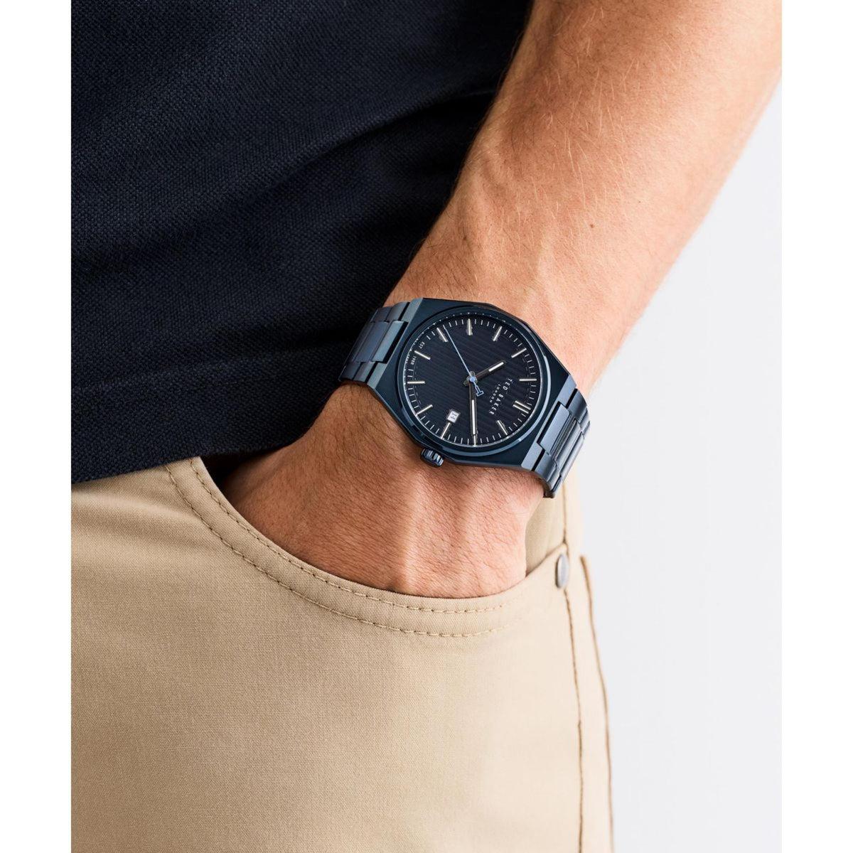 Men's blue dial watch worn on wrist, stainless steel bracelet and round face