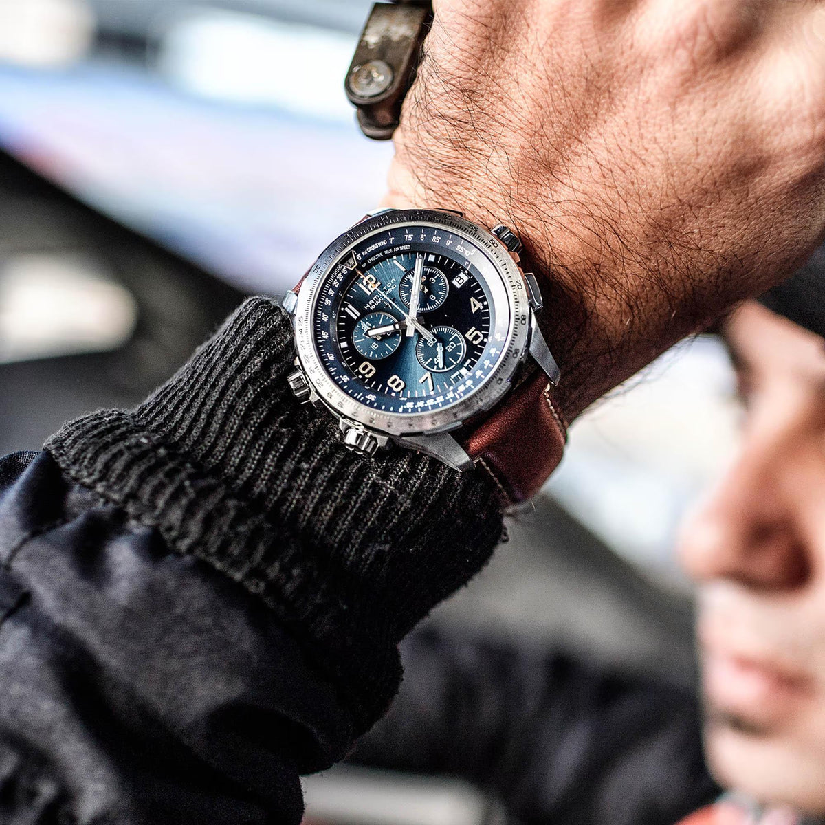 Men's aviation quartz watch on wrist, blue dial with subdials, brown leather strap