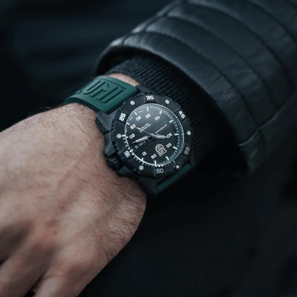 Men's Luminox automatic watch on wrist with dark green rubber strap and grey dial