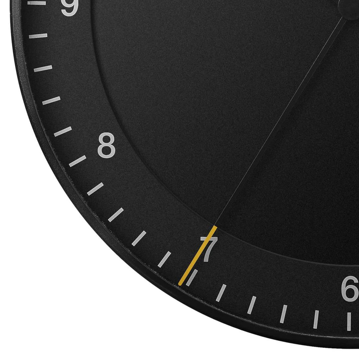 Braun wall clock dial detail showing white hour 8, tick marks, and yellow accent