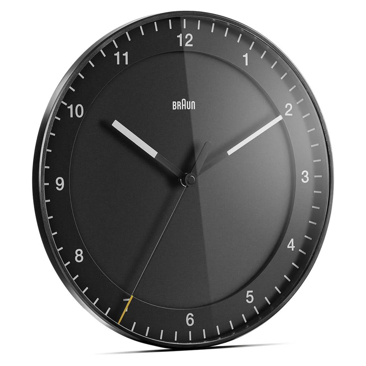 Braun wall clock close-up with dark gray dial, white numerals, and silver hands