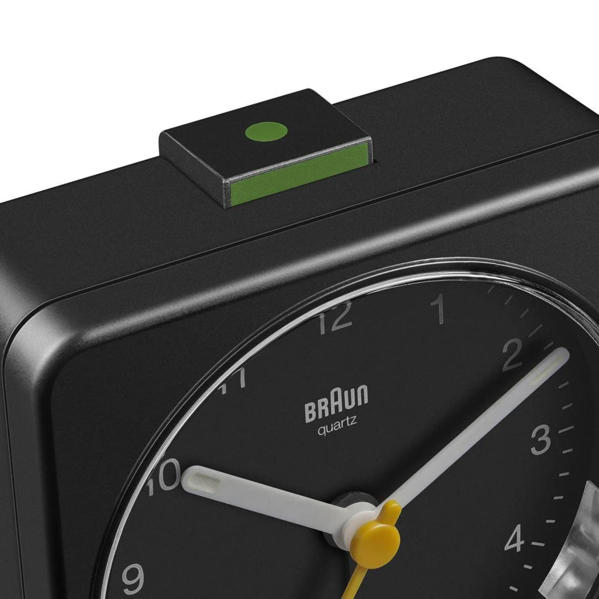Black quartz alarm clock side view with dial and yellow hands