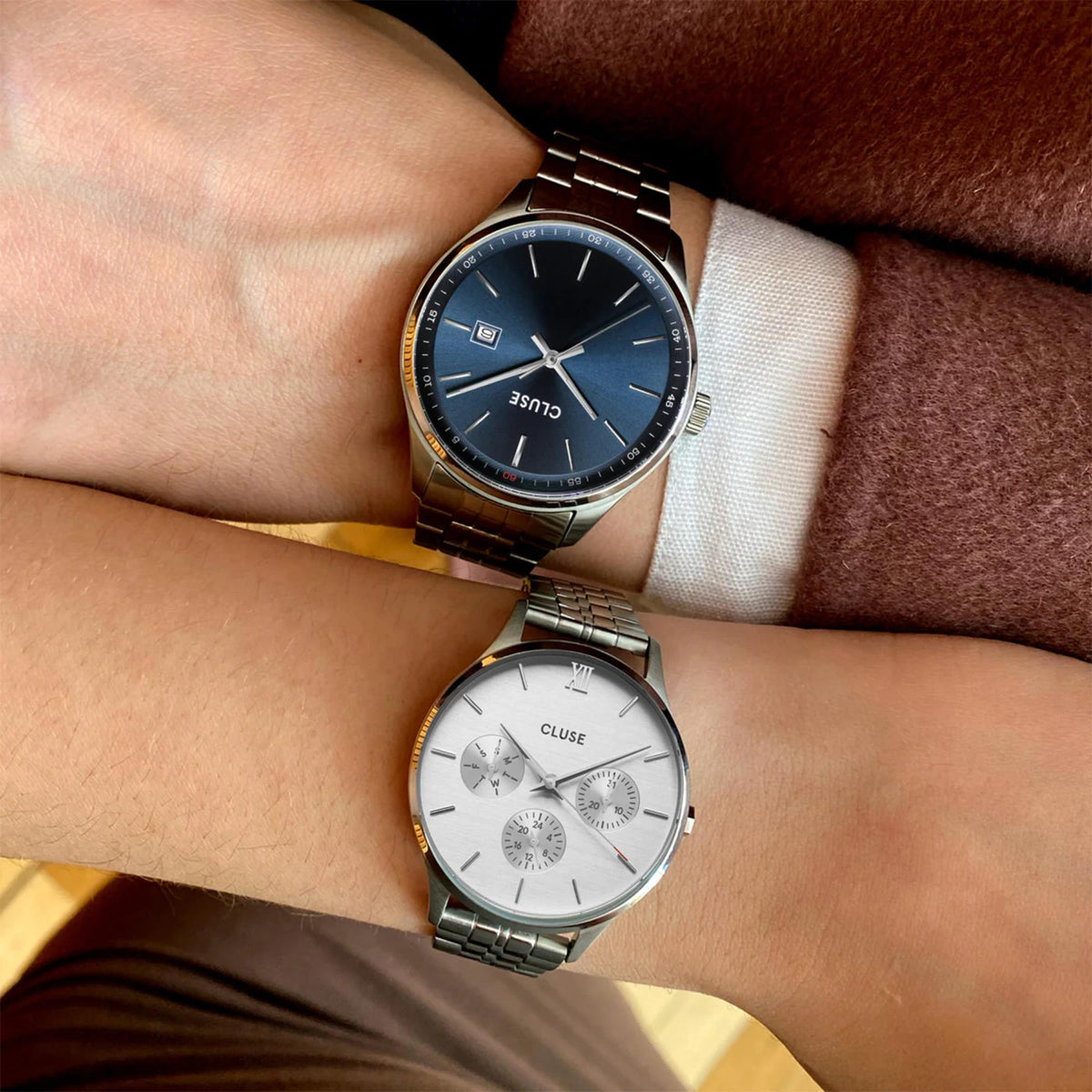 Two steel wristwatches: one blue dial, one light dial with three-hand movement