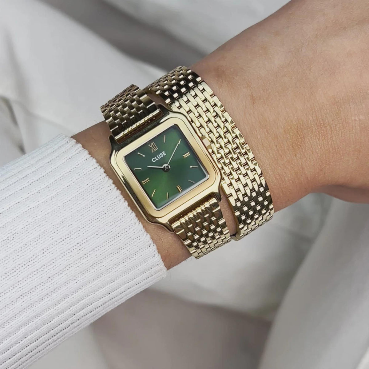 Gold-tone wristwatch with green dial and textured metal mesh bracelet strap