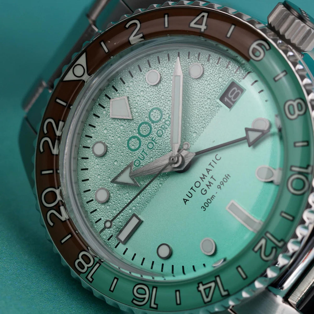Close-up of mint green textured dial with luminous markers and date window