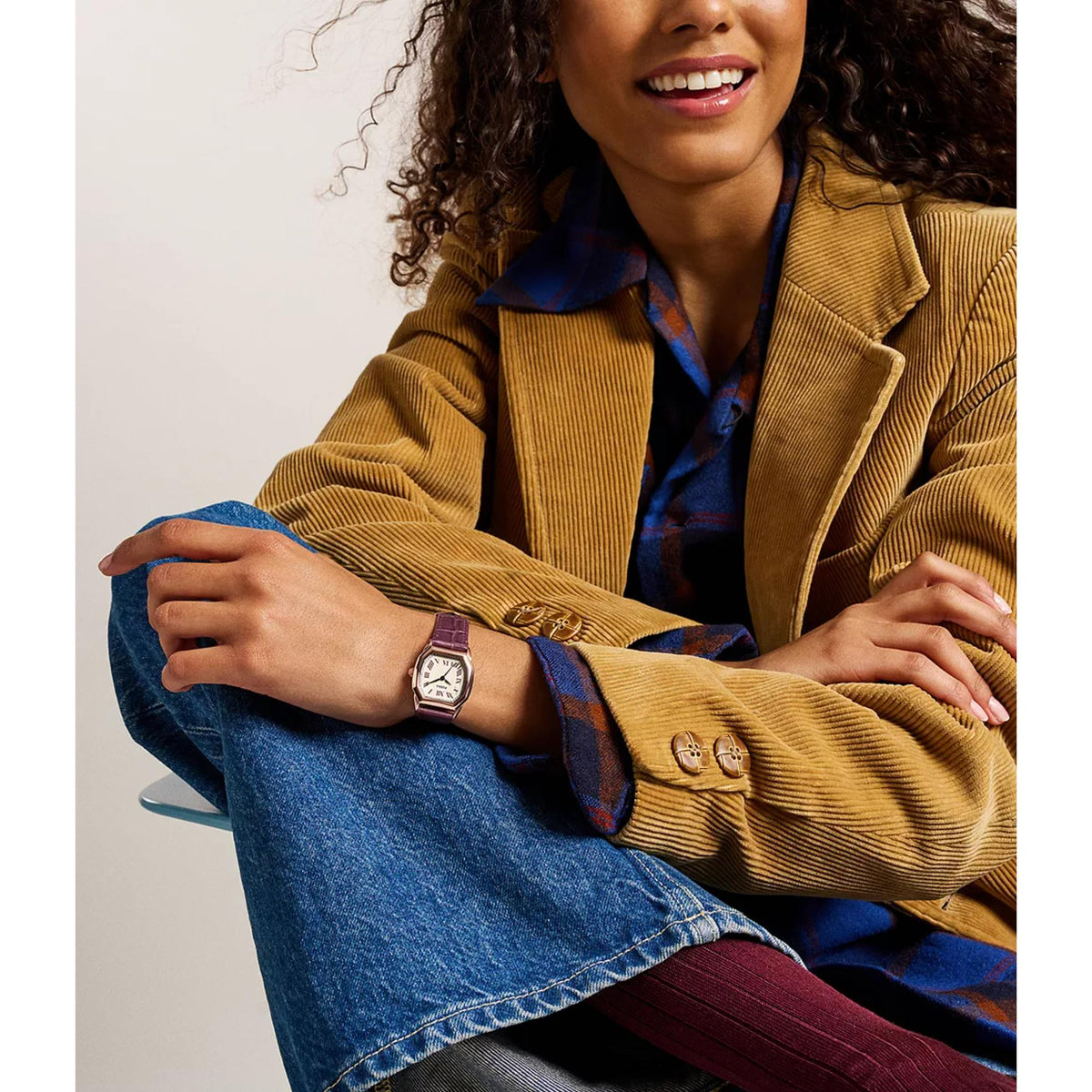 Women’s leather quartz watch on wrist, rose-gold case with white Roman numeral dial